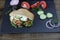 Pita - sandwich, sabiche stuffed with chicken, tomatoes, cucumbers, salad on a black plate and wooden background