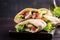 Pita stuffed with chicken, tomato and lettuce on wooden background.