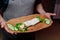 pita with vegetables and chopped cucumbers on a cutting board in the hands