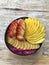 Pitaya breakfast bowl Acai superfood smoothie bowl with mango, strawberry, banana, dragon fruit, granola and coconut