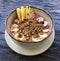 Pitaya breakfast bowl. White rustic black wooden background. Acai superfood smoothie bowl with pineapple slices, banana