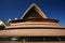 Pitched and pointy roof with exposed concrete beams and large glass window on pink podium of Sydney Opera House Australia