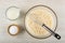 Pitcher with milk, salt in bowl, whipped eggs with milk, whisk in bowl on wooden table. Top view