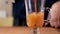 Pitcher pours Thai iced tea into a glass