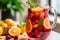 pitcher of tangy fresh fruit ripe sangria with mint leaves and strawberry slices, maroon in a large