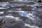 Pits and puddles on terrible road covered with old carpets in spring