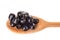 Pitted black olives on wooden spoon isolated