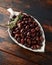 Pitted kalamata olives in bowl on rustic wooden background