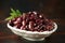 Pitted kalamata olives in bowl on rustic wooden background
