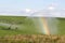 Pivot running in field with beautiful rainbow on sunny day . July 22, 2019, O`Nell, Holt county, Nebraska