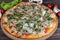 Pizza with bacon and cheese, herbs and cherry tomatoes. With mozzarella, shrimps and octopuses, mussels and other products on a