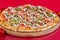 Pizza with bacon and cheese, herbs and cherry tomatoes. With mozzarella, shrimps and octopuses, mussels and other products on a