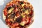 Pizza called capricciosa in the Neapolitan language with mushrooms, ham, artichokes, tomato, mozzarella in the cardboard box