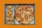 Pizza and cheese balls in paper box isolated on orange background. This image stacked with clipping path.