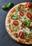 Pizza with cherry tomatoes, mozzarella cheese, jalapeno pepper, capers and fresh basil.