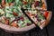 Pizza with chicken and salad on wood background