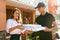 Pizza Delivery. Courier Giving Woman Boxes With Food Outdoors