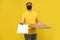 Pizza delivery man in mask looking at camera isolated on yellow background. Coronavirus 2019-ncov concept