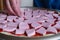 pizza dough smeared with ketchup and with slices of sausage as background