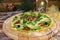 Pizza with fresh lettuce, jamon Serrano ham slices served on wooden plate with Christmas new year decoration