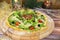 Pizza with fresh lettuce, jamon Serrano ham slices served on wooden plate with Christmas new year decoration