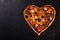 Pizza heart love Valentine`s Day romantic Italian restaurant dinner food. Prosciutto, olives, tomatoes, parsley, basil