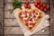 Pizza heart shaped with pepperoni, tomatoes