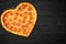 Pizza heart for Valentine`s Day romantic concept copy space on rustic dark black background. Top View. Flat lay