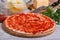 Pizza ingredients: base, tomato sauce, herbs, pineapple, cheese
