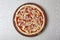 Pizza ingredients, pizza dough with tomato sauce, onions slices and mozzarella cheese on wooden board  on gray background.