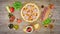 Pizza with ingredients on wooden plate on the table - stop motion animation, 4K