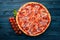 Pizza Lardon. Bacon, cherry tomatoes, sausage salami. On a wooden background.