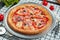 Pizza with a large number of toppings: salami, bell pepper, olive, cheese. Pizza in composition with ingredients on a white