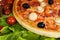 Pizza with a lettuce\'s leaves and tomatoes