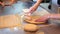 Pizza maker prepare dough in restaurant kitchen, making holes stretching dough