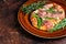 Pizza with prosciutto parma ham, arugula salad and parmesan cheese in a rustic plate. wooden background. Top view. Copy