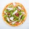 Pizza with prosciutto (parma ham), arugula (salad rocket) and parmesan top view