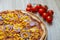 Pizza with red sauce, ham, mozarella, corn and onion rings detail