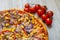 Pizza with red sauce, ham, mozarella, corn, onion rings, red bell pepper, mushroom detail