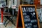 Pizza restaurant `La fucina`, Javastraat street, Amsterdam, Netherlands. View of advertising board against outside tables and chai