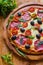 Pizza with salami, black olives and tomatoes