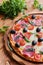 Pizza with salami, black olives and tomatoes