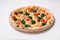 Pizza with sausages, tomato and spinach isolated