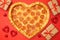 Pizza shape heart pizza pepperoni for Valentines day with gift box on red paper background