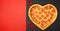 Pizza shaped heart top view Valentine`s Day on black and red background