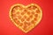 Pizza shaped heart top view Valentine`s Day on red background