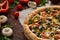 Pizza still life. Freshly baked pizza and its components arranged on wooden background.