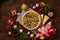 Pizza still life. Freshly baked pizza and its components arranged on wooden background.