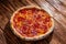 Pizza with tomato sauce, mozzarella, salami, chili, honey on wood background, copy space