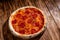 Pizza with tomato sauce, mozzarella, salami, chili, honey on wood background, copy space